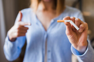 nainen kannustamassa tupakoinnin lopettamiseen nikotiinipurkan avulla.